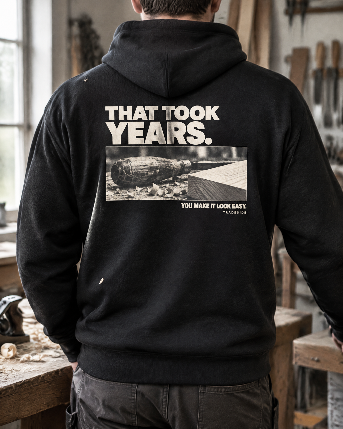 That Took Years hoodie, back print, worn by a joiner in a workshop